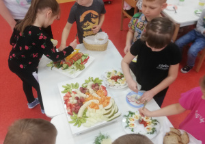 przedszkolaki wybierają produkty do wykonania fantazyjnych kanapek